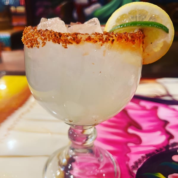 A Los Gallos Mexican Grill margarita with a chili-lime rim, ice, and a lemon-lime garnish.