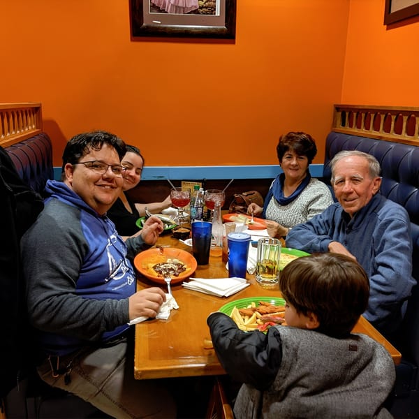 A family of five, including a child, enjoying a meal at Los Gallos Mexican Grill.